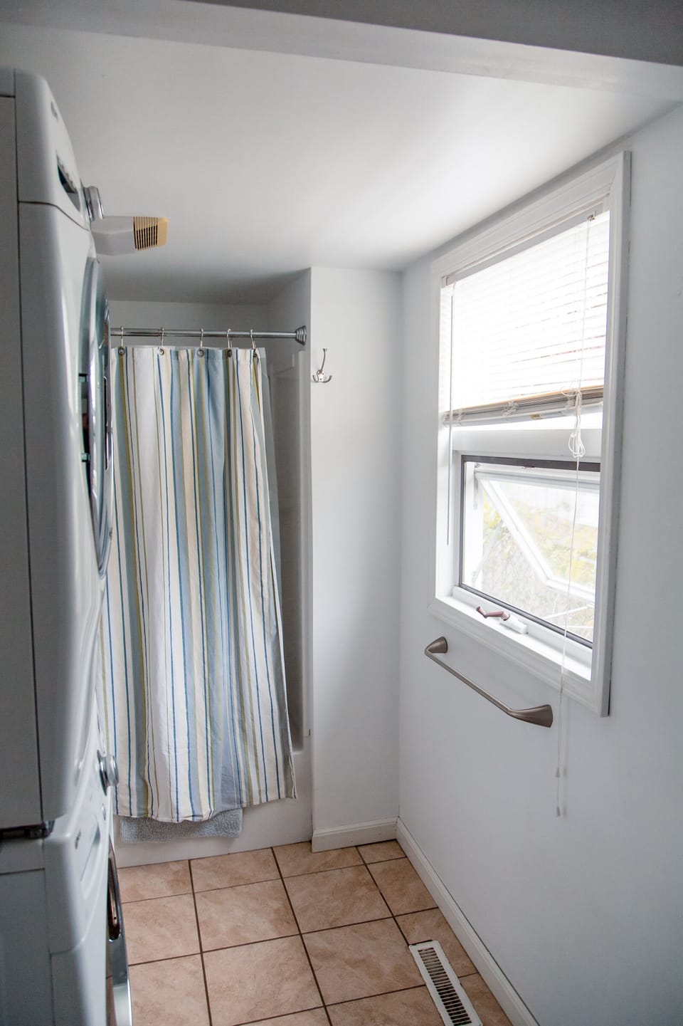 Bathroom with tub and show, toilet, and full size washer and dryer and sink area