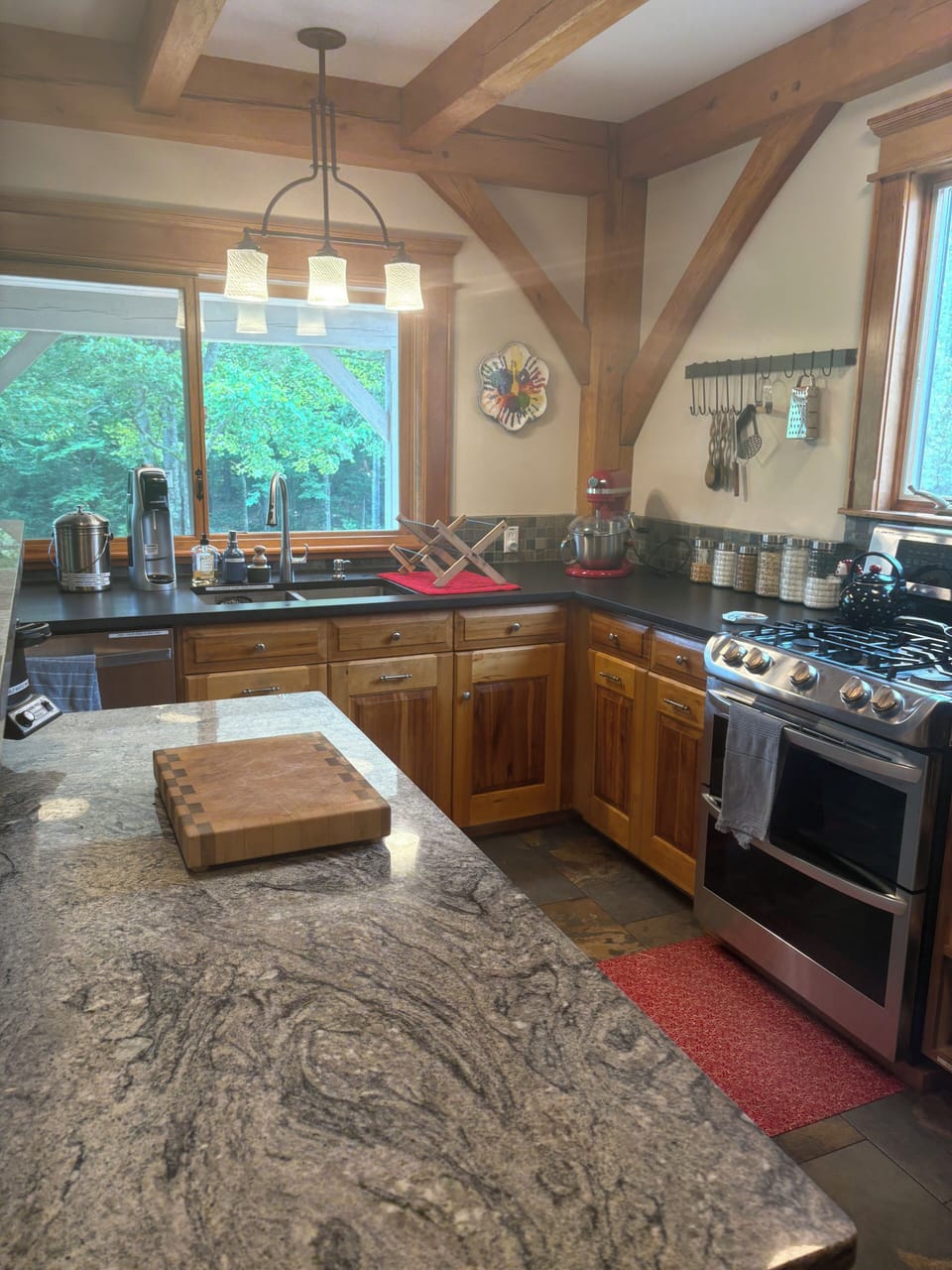 Kitchen island looking over the covered porch.  Granite counters. Gas stove/oven