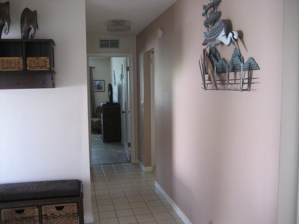 Entrance hallway with bench leading to Second Bedroom & Laundry Room on left.