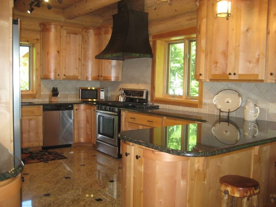 Kitchen - Curved Knotty Alder Cabinetry w/ Granite
