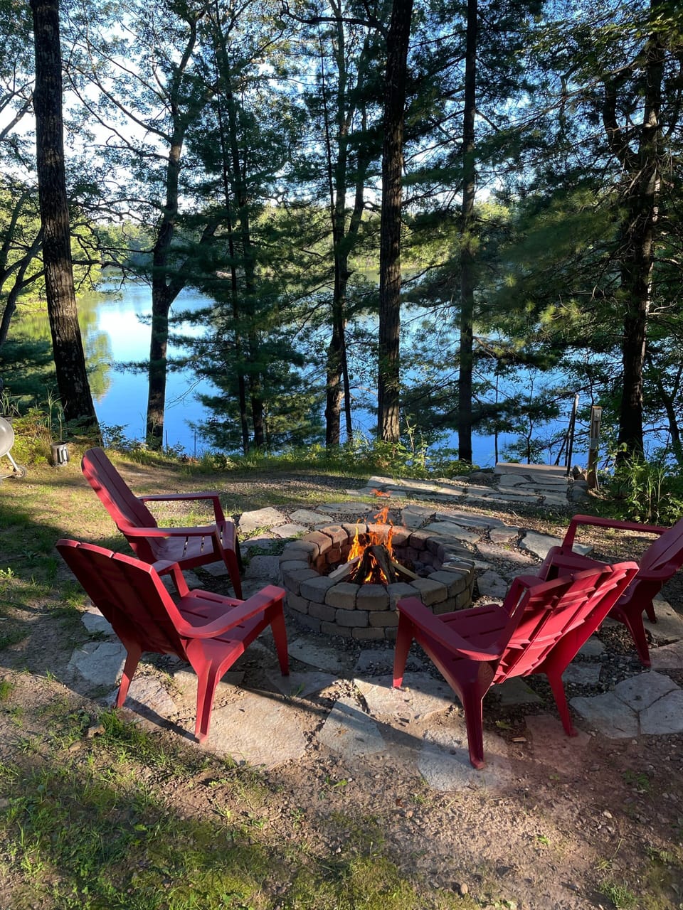 Fire pit overlooking the lake with 4 Adirondack chairs