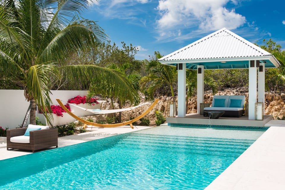 Relax on the double chaise lounge under the shade of the cabana