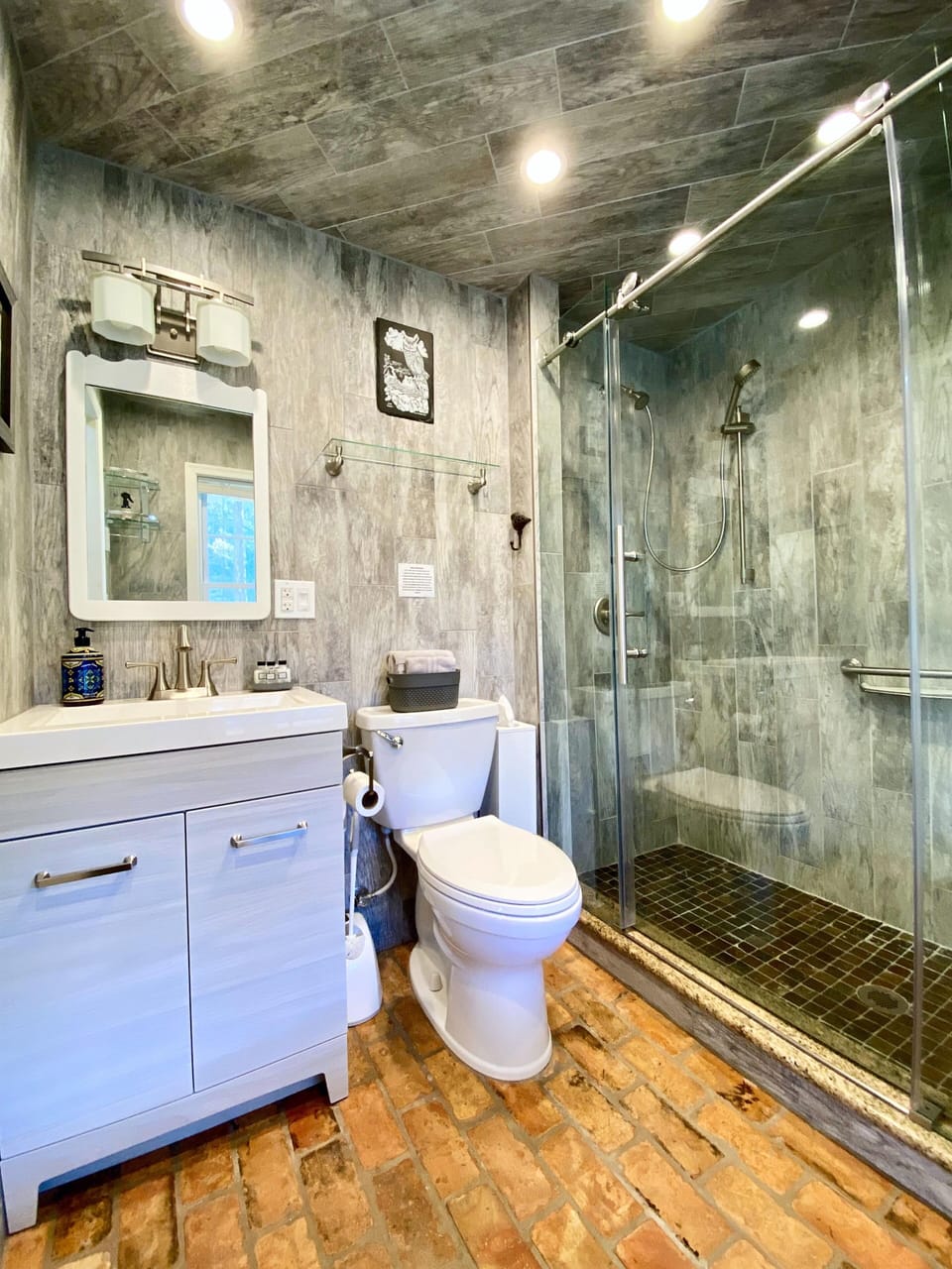 The stocked bathroom features porcelain tile, sink, toilet, walk-in shower.