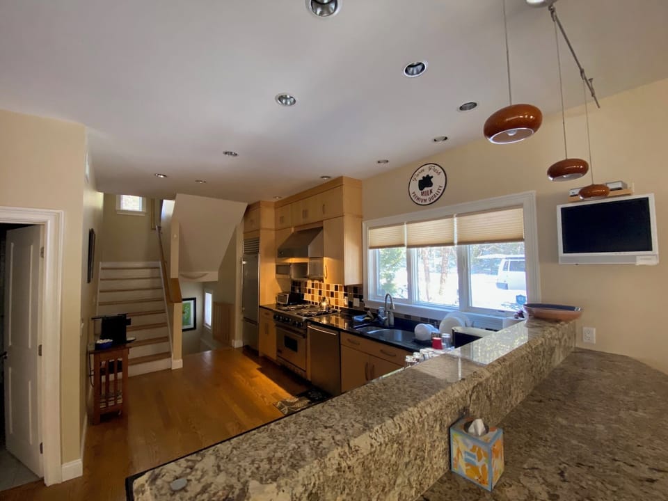 View of kitchen from the bar. Door on left is main floor bathroom.