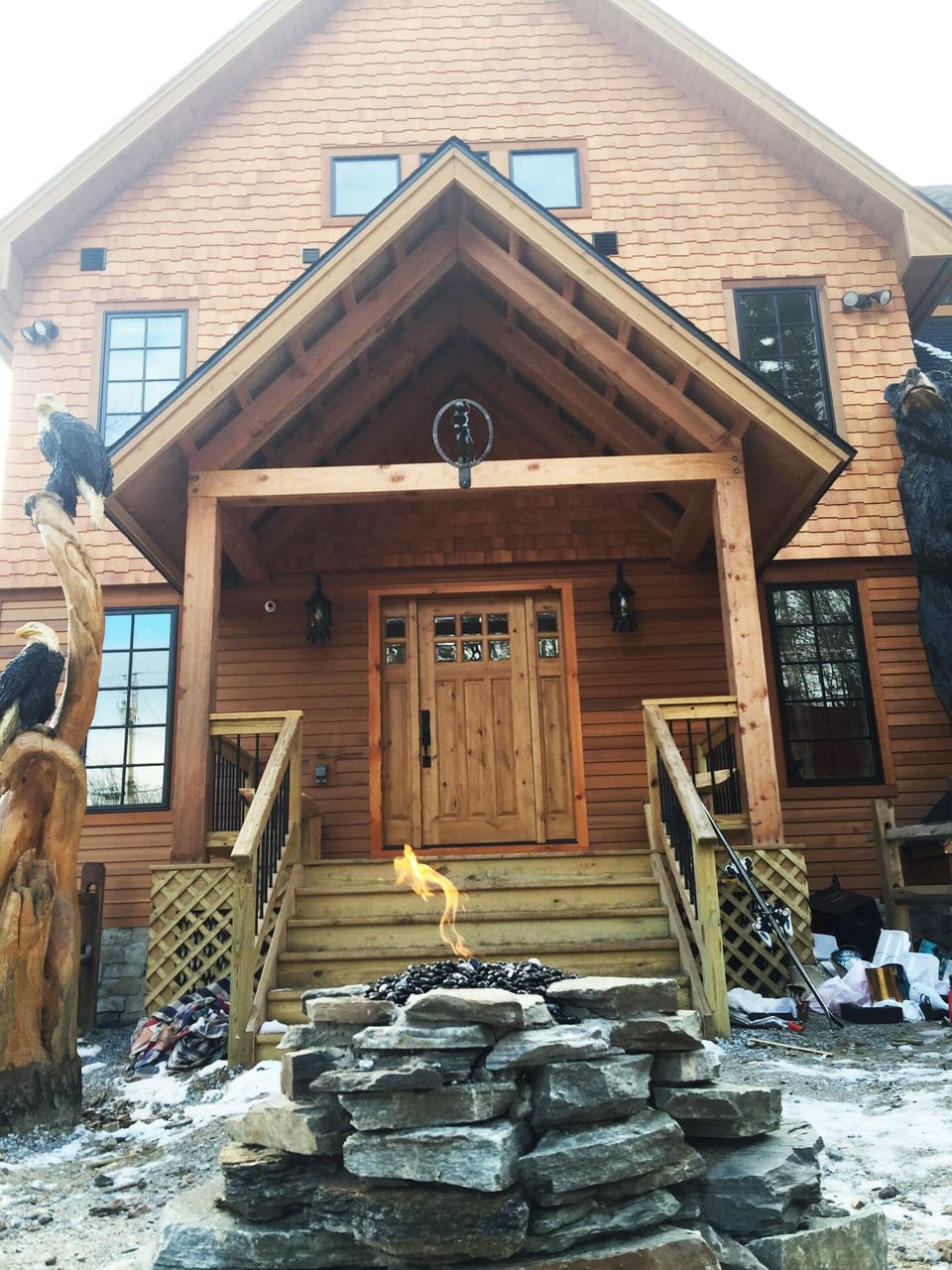 Dramatic front of house with bears, eagles, old man winter totem poles with fire