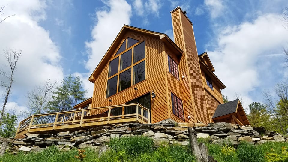 View of home from stream below spacious back deck
