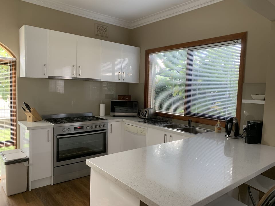 Kitchen with stone benchtops, microwave, large oven and everything you need.