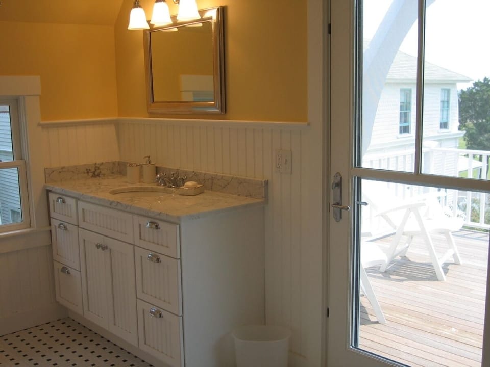 Bathroom with marble vanity, tiled floor, soaking tub and park view