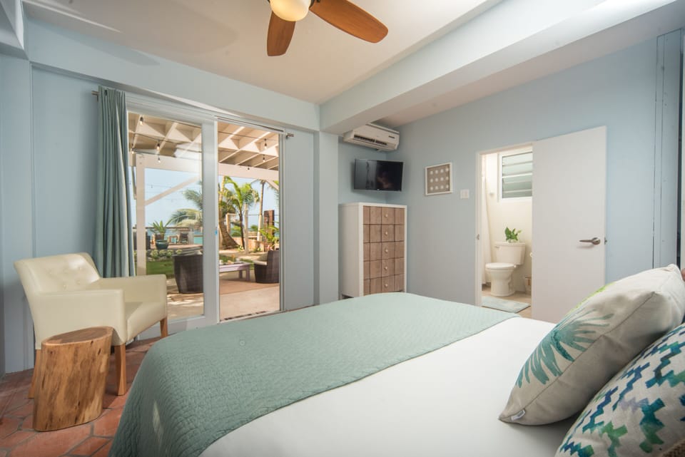 The ocean-facing bedroom features a comfy queen bed, A/C, TV, and en suite bath.
