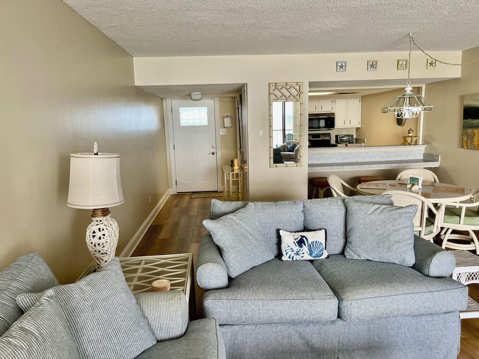 Living room to front door entry to kitchen