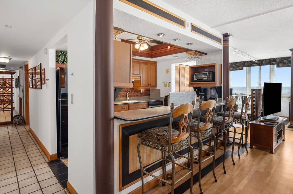 Breakfast bar & kitchen with hallway to Master suite & unit entrance.