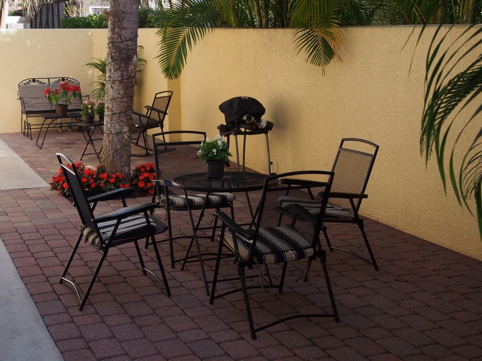 Facing other end of the courtyard, BBQ, tables, glider.