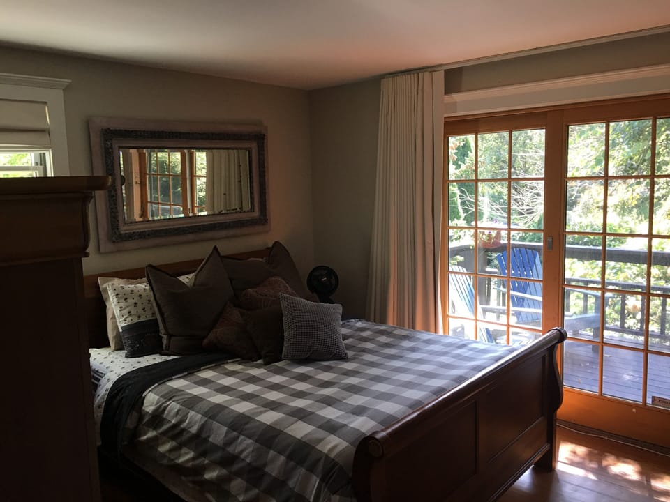 Bedroom on main floor with sliding French door to front deck
