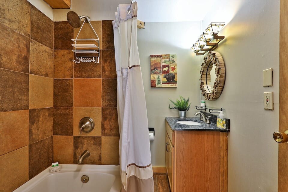 The shower, tub and sink are together in one compact bathroom.