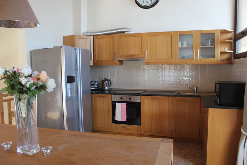 Kitchen with American fridge/freezer, microwave, oven, hob and dishwasher. 