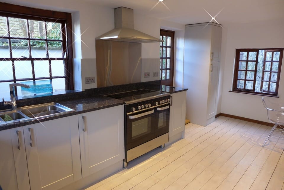 Newly appointed kitchen, with electric range cooker and granite worktop.