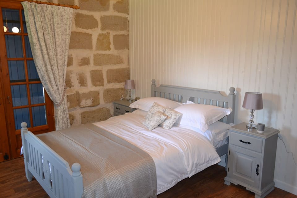 Main bedroom with double bed &patio doors onto sun terrace, original stone wall.