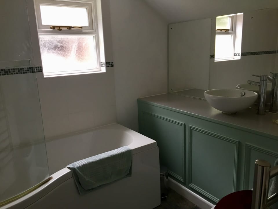 Green bedroom en-suite with bath. 