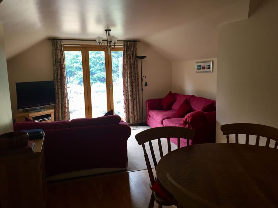 Living room with 4 seater and 2 seater sofas, and Oak dining table and chairs. 