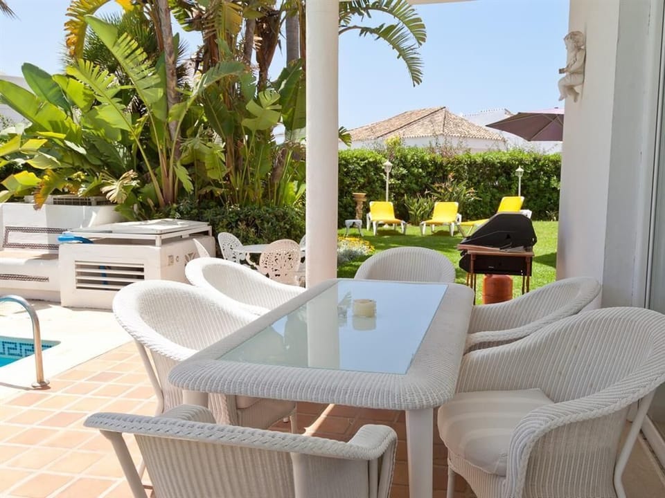Outdoor dining area for six with views to the gardens and pool