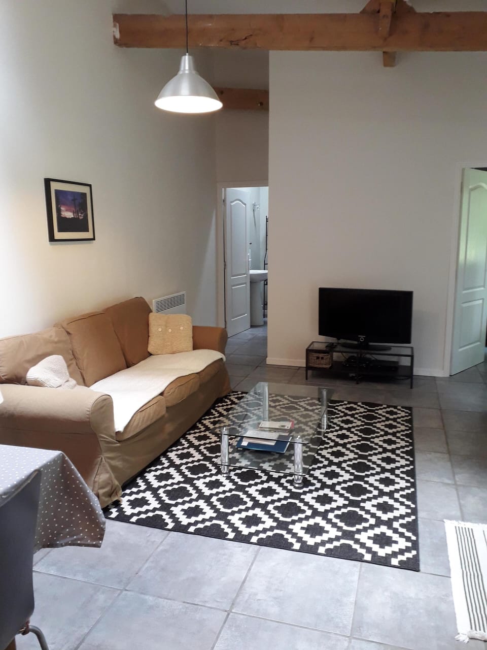 Lounge area, leading to bathroom (back left) and bedroom (back right)
