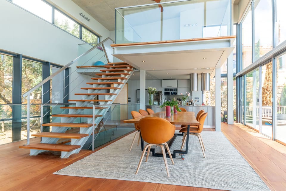 Bright open-plan dining and living space with floating staircase — Villa Equador, luxury holiday villa in Cascais