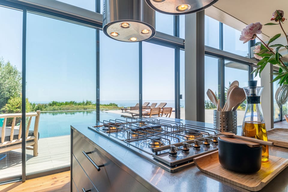 Modern kitchen with gas cooktop and pool view — Villa Equador, luxury holiday villa in Cascais
