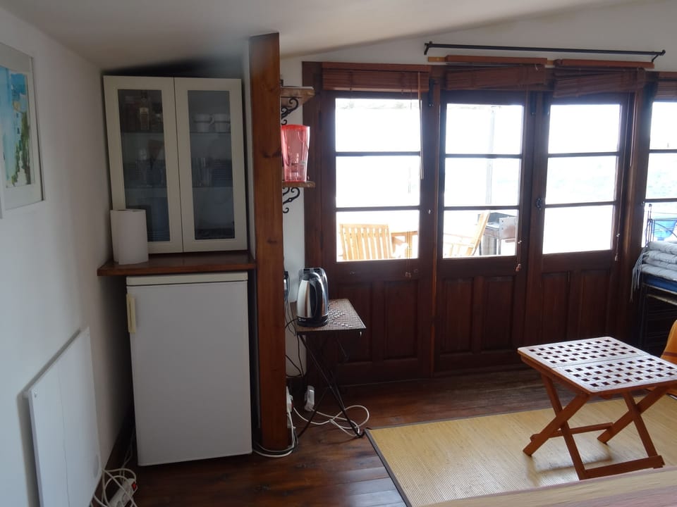 The sunroom is equipped with a fridge and cooking utensils