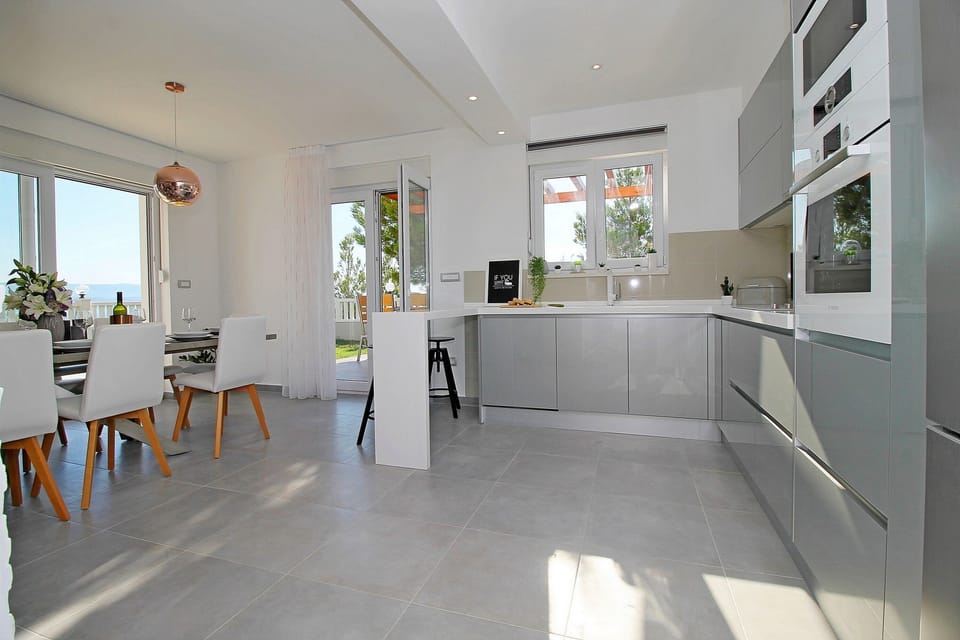 Fully equipped and modern kitchen connected with outdoor dining area and grill