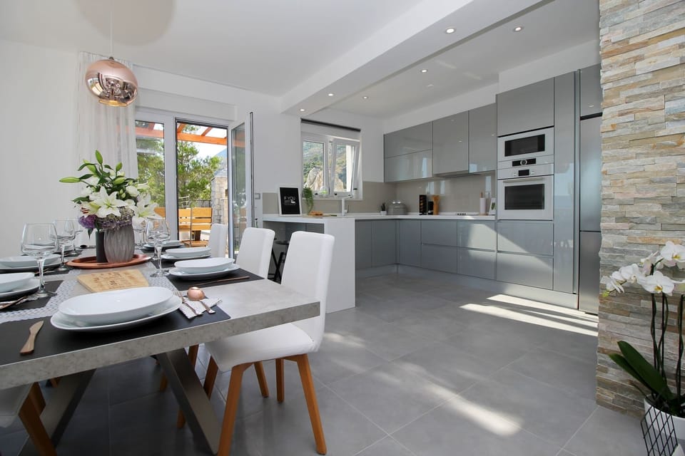 Fully equipped and modern kitchen connected with outdoor dining area and grill