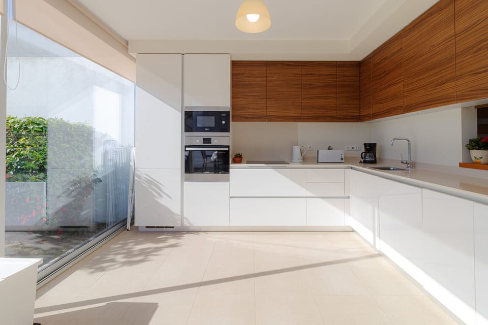 Modern open-plan kitchen with wood cabinetry — Villa Blue Sagres G, holiday villa in Vila do Bispo