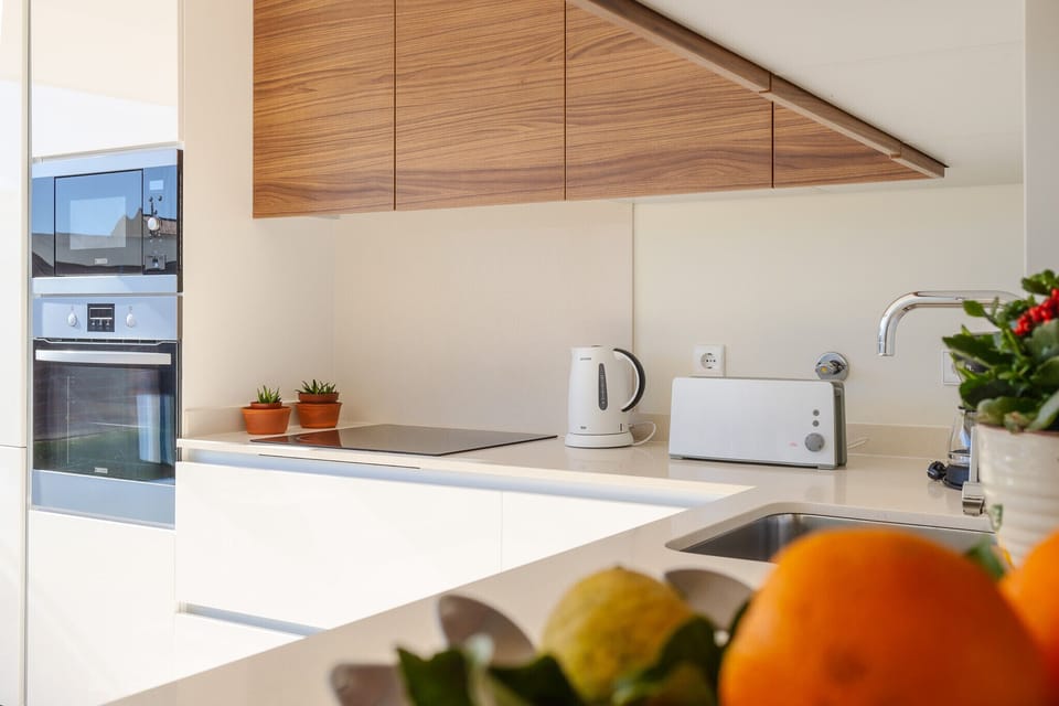 Modern kitchen with wooden ceiling panels and white countertops — Villa Blue Sagres G, holiday villa in Vila do Bispo