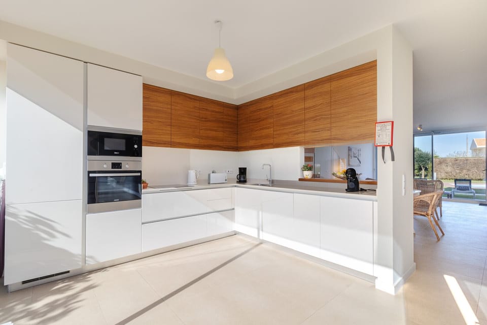 Modern open-plan kitchen with wooden upper cabinets — Villa Blue Sagres G, holiday villa in Vila do Bispo