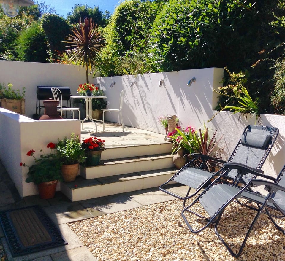 Sun trap patio with table and chairs, bbq, chiminea and sun-loungers