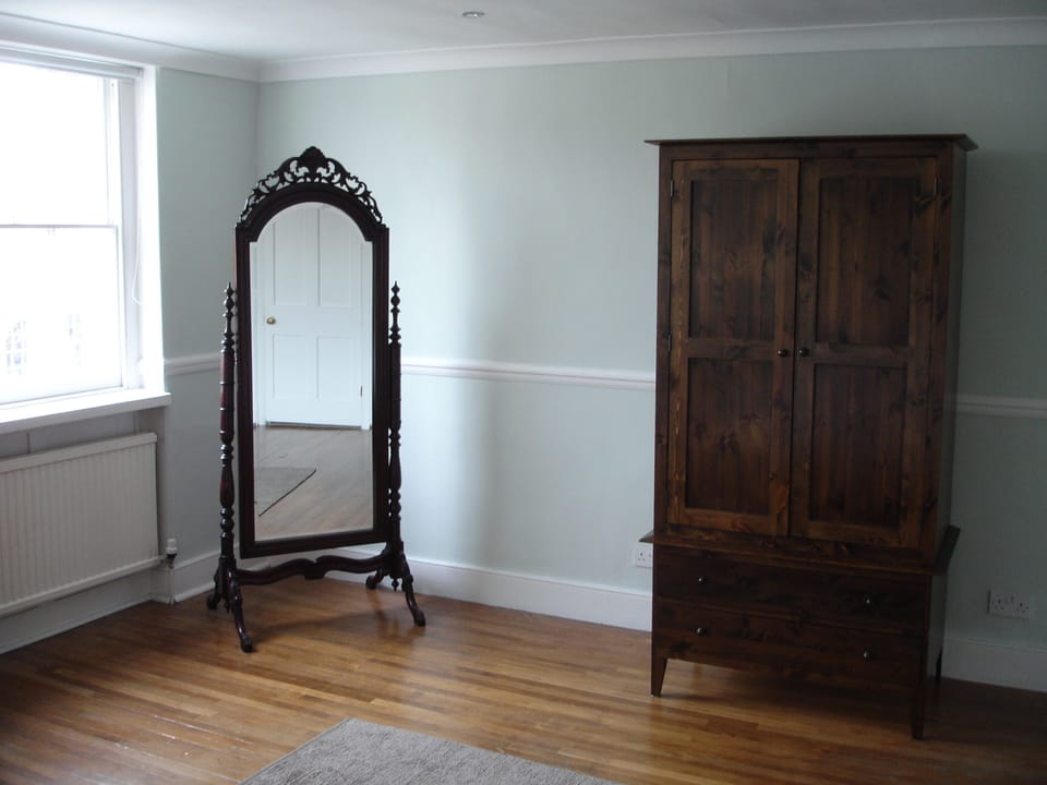Mirror & wardrobe in large master bedroom. Two windows look out to John St.