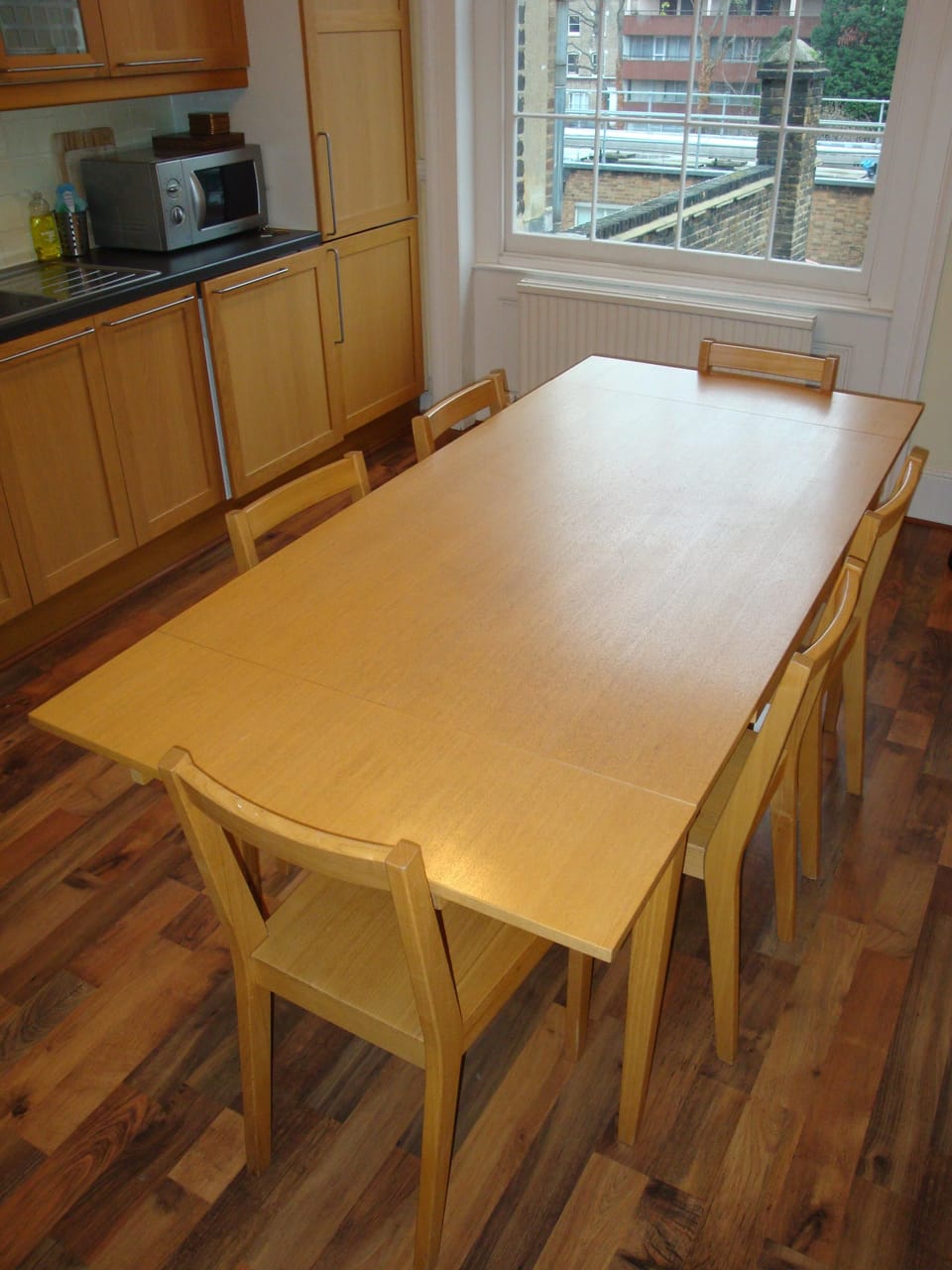 Dining table and 6 chairs is in the kitchen.