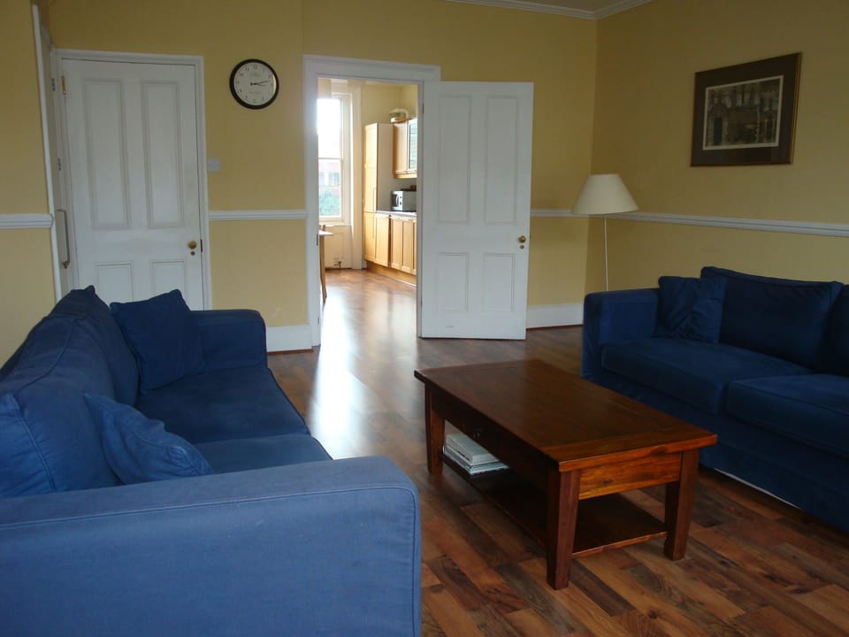 Spacious living room leads into kitchen. The other door leads to hallway/stairs.