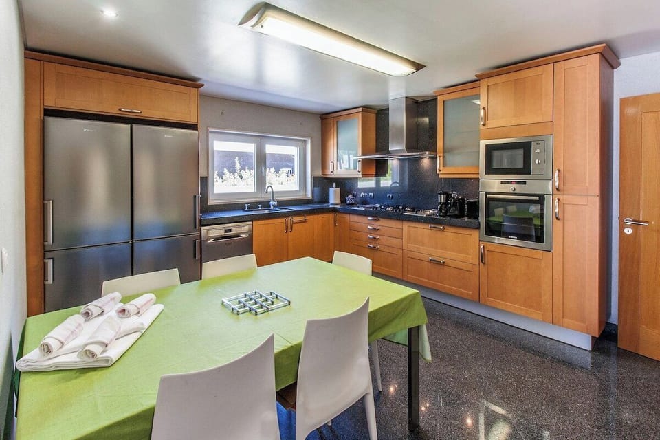 Modern kitchen and dining area with green table — Villa Amendoa, holiday villa in Verdizela