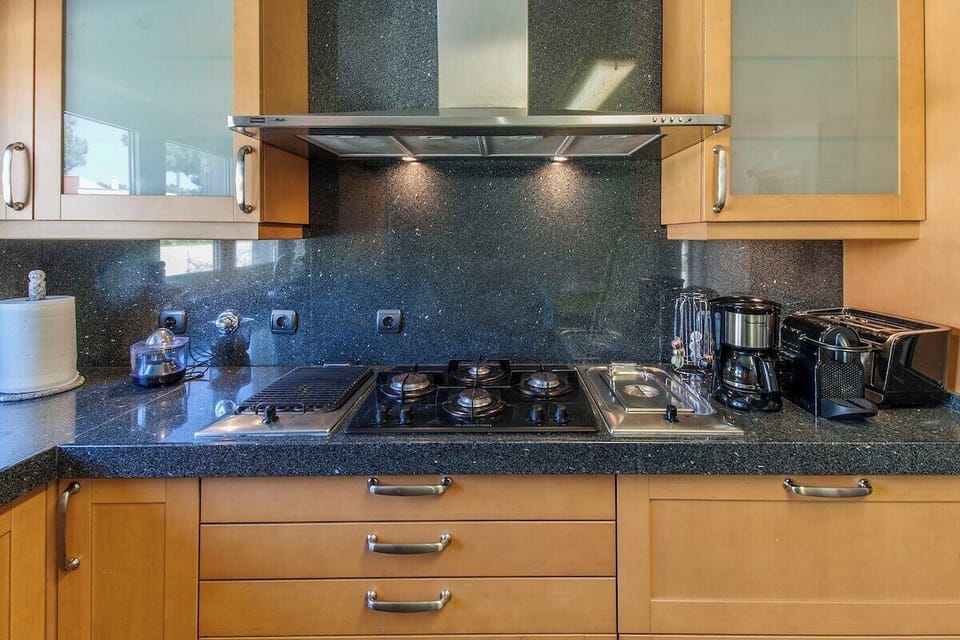 Modern kitchen with dark speckled countertop and gas cooktop — Villa Amendoa, holiday villa in Verdizela