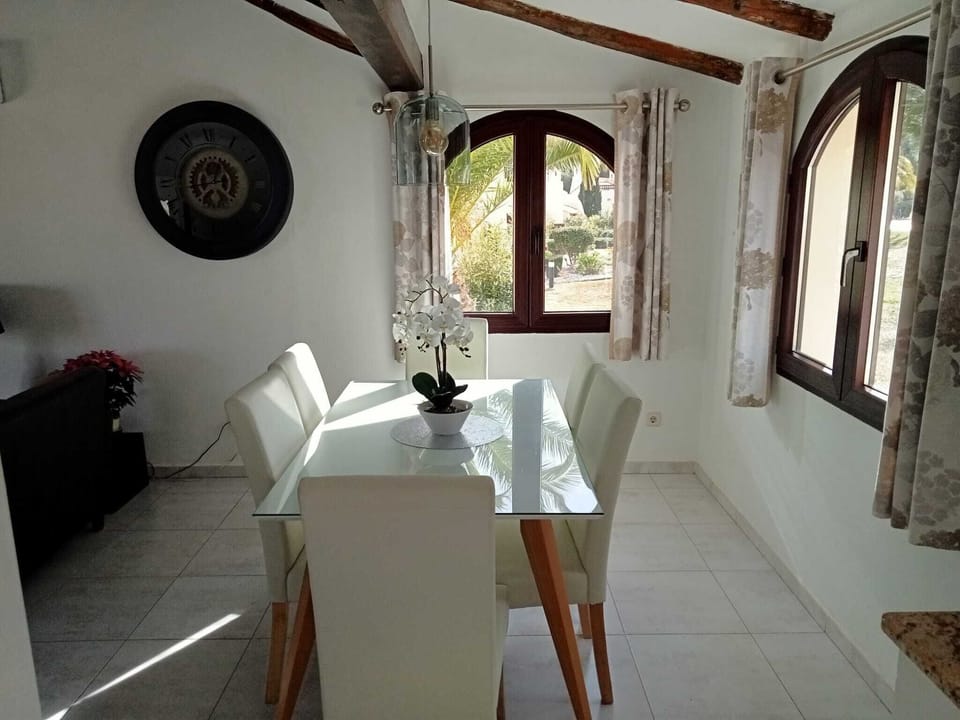 Dining area with seating for 6 at a toughened glass topped table.