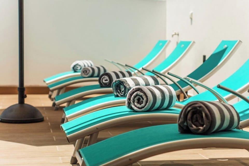 Row of turquoise sun loungers with rolled towels — Villa Tucana, holiday villa in Lagos