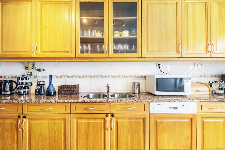 Fully equipped kitchen with golden wood cabinetry and granite worktops — Villa Tucana, holiday villa in Lagos