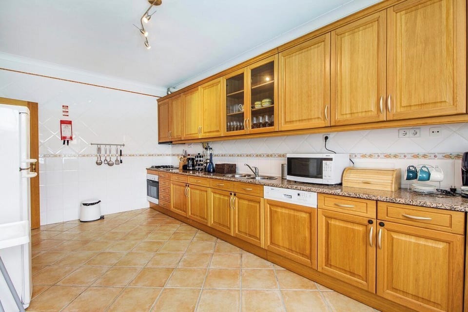 Spacious kitchen with wooden cabinetry and granite worktops — Villa Tucana, holiday villa in Lagos