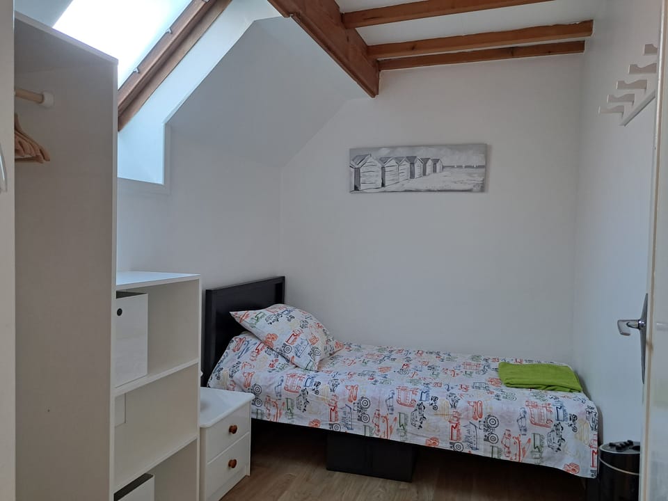 The single bedroom, with built in shelves and hanging space.