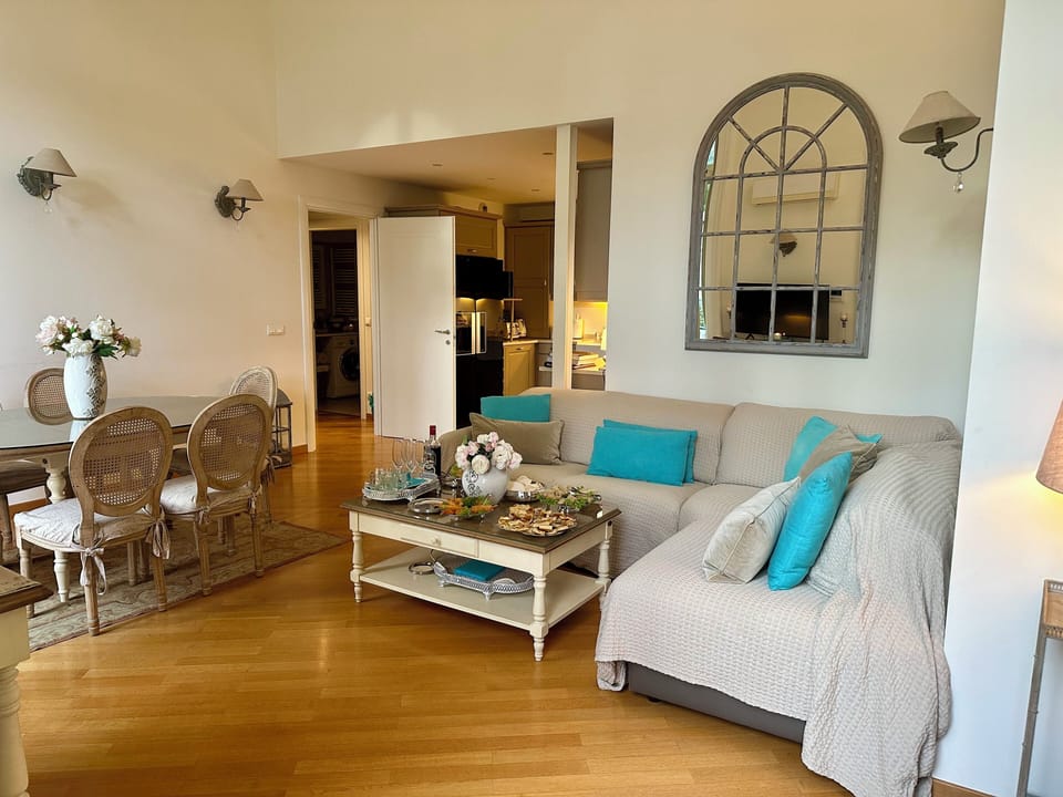 Air-conditioned furnished living/dining room with kitchen in the background