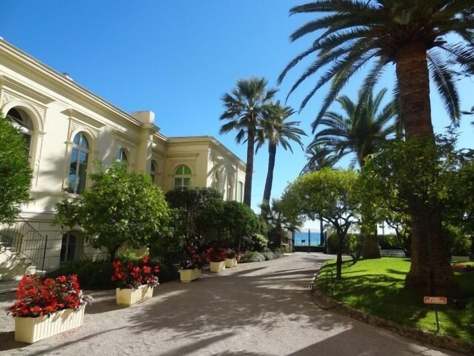 View of apartment's tall windows from the shared gardens of Le Regina residence