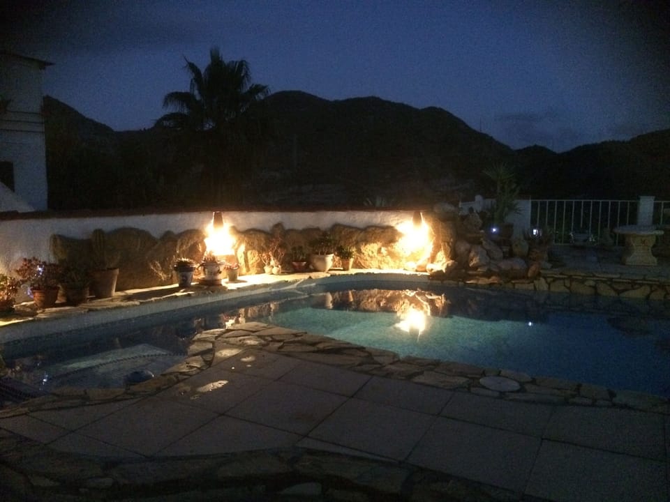 private pool by night with views of surrounding hills