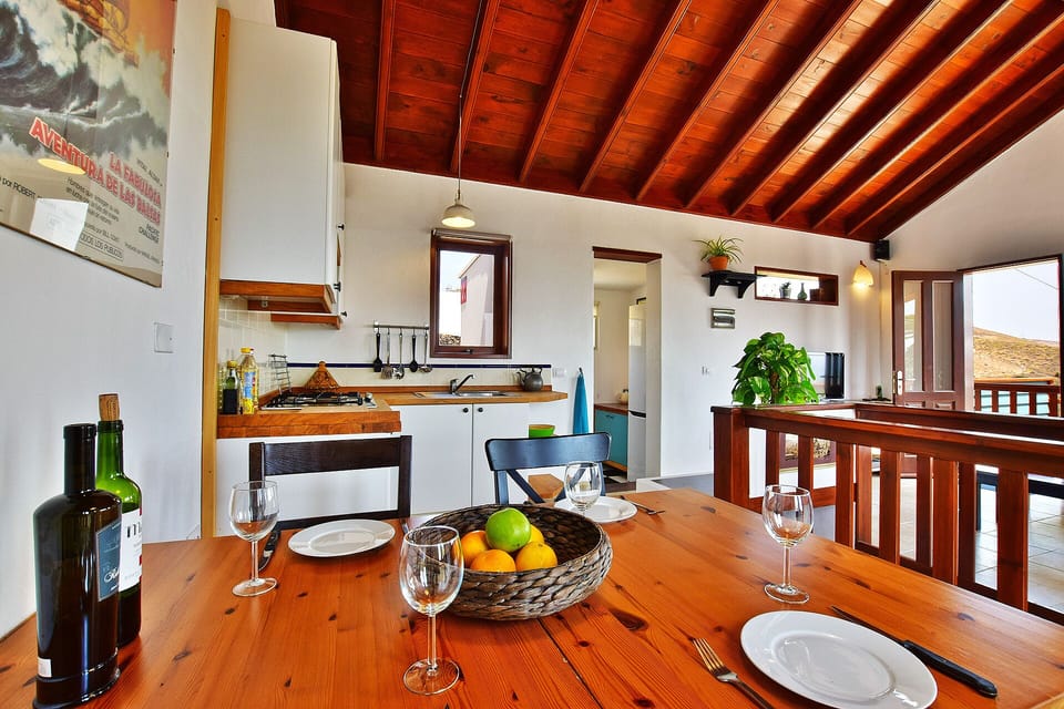 Dining area with kitchen and storage room with fridge/freezer in the background