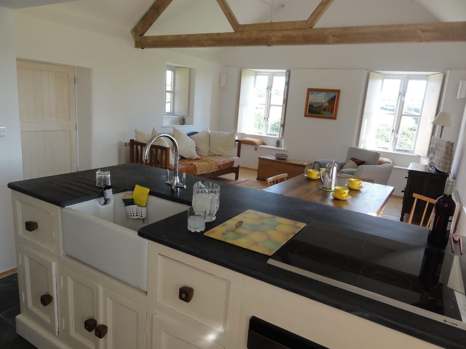 Kitchen with lovely slate work tops and open plan living area, very sociable to cook in.