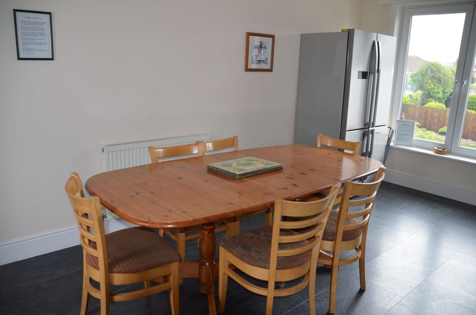 Large dining table with two extra chairs in the lounge
